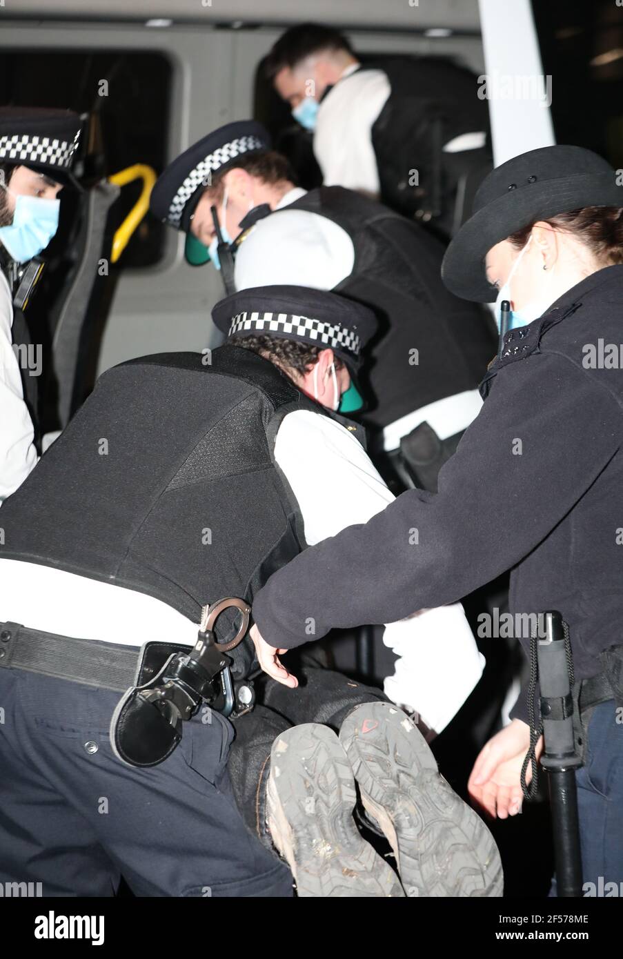 Un manifestant contre le climat est placé dans un véhicule de police après s'être fixé aux portes devant Downing Street à Westminster, Londres. Date de la photo: Mercredi 24 mars 2021. Banque D'Images