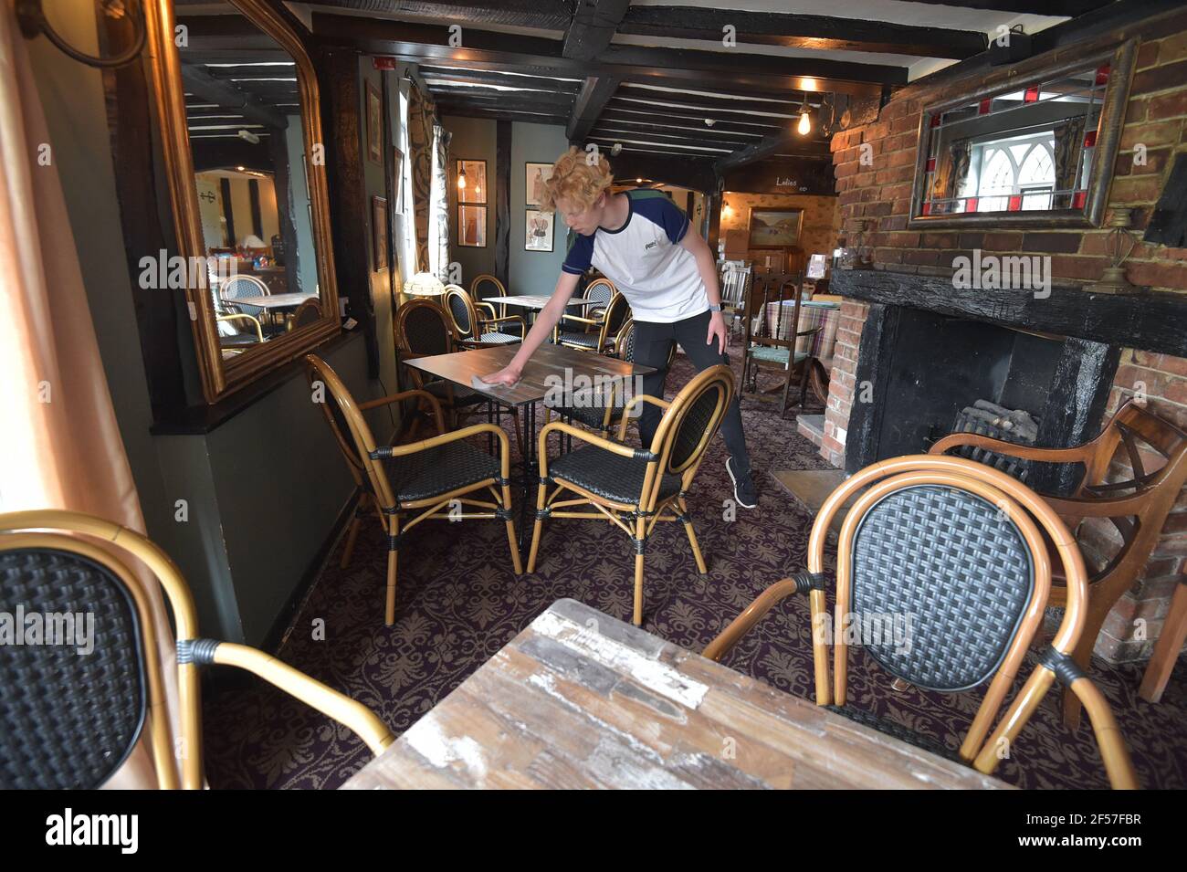 Photo du dossier datée du 30/06/20 du sous-chef Cameron Sparkes, nettoyant les tables et les chaises neuves au Fox on the Green à Finchingfield, Essex. Selon Boris Johnson, les propriétaires de pub pourraient être autorisés à exiger des clients qu'ils fournissent la preuve qu'ils sont vaccinés contre le coronavirus. Date de publication : le mercredi 24 mars 2021. Banque D'Images