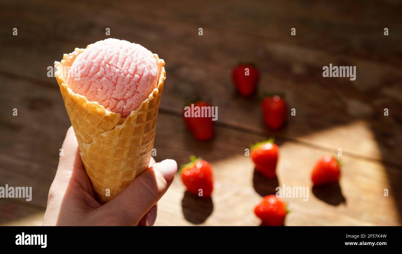 Gros plan sur la main de femme tenant la crème glacée à la framboise Banque D'Images
