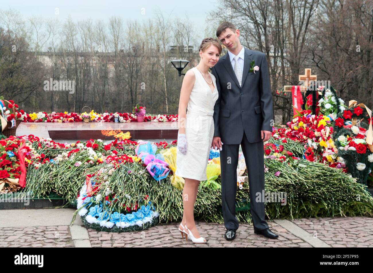 Couple de jeunes mariés debout près du mémorial de guerre avec une lumière éternelle. Mariage russe Banque D'Images