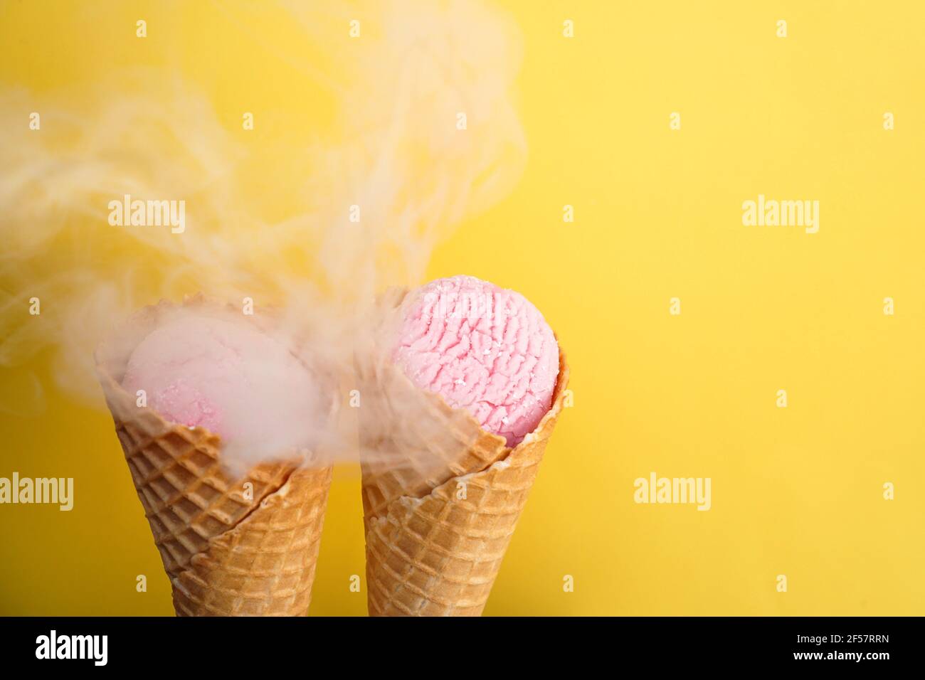 Glace délicieuse dans un cornet de gaufres sur un jaune arrière-plan couvert de fumée Banque D'Images