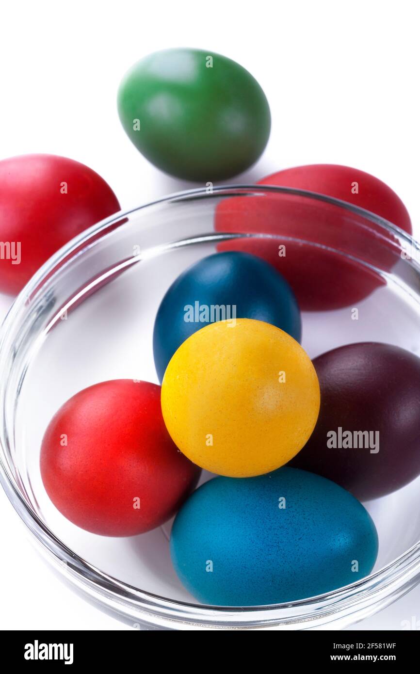 Œufs de Pâques colorés dans un bol en verre sur un blanc arrière-plan Banque D'Images