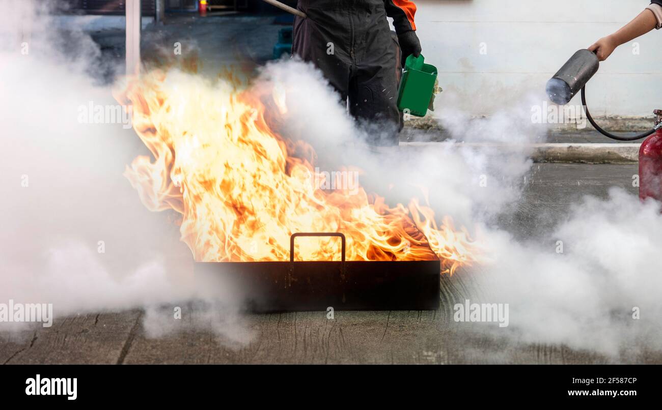 L'homme enseigne ou forme à utiliser des extincteurs au dioxyde de carbone (CO2) pour éteindre les incendies de carburant. Banque D'Images