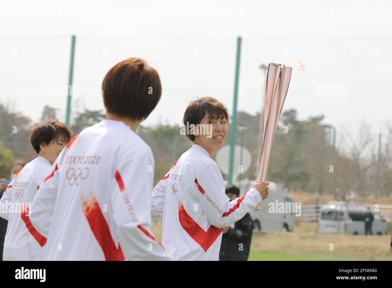 Fukushima, Fukushima du Japon. 25 mars 2021. Iwashimizu Azusa (R) et d'autres membres de 'Nadeshiko Japon', l'équipe nationale de football des femmes du Japon, courent comme torchbearers dans la première partie du relais de la torche pour les Jeux Olympiques de Tokyo au J-Village National Training Center à Futaba, Fukushima du Japon, le 25 mars 2021. Credit: Du Xiaoyi/Xinhua/Alay Live News Banque D'Images