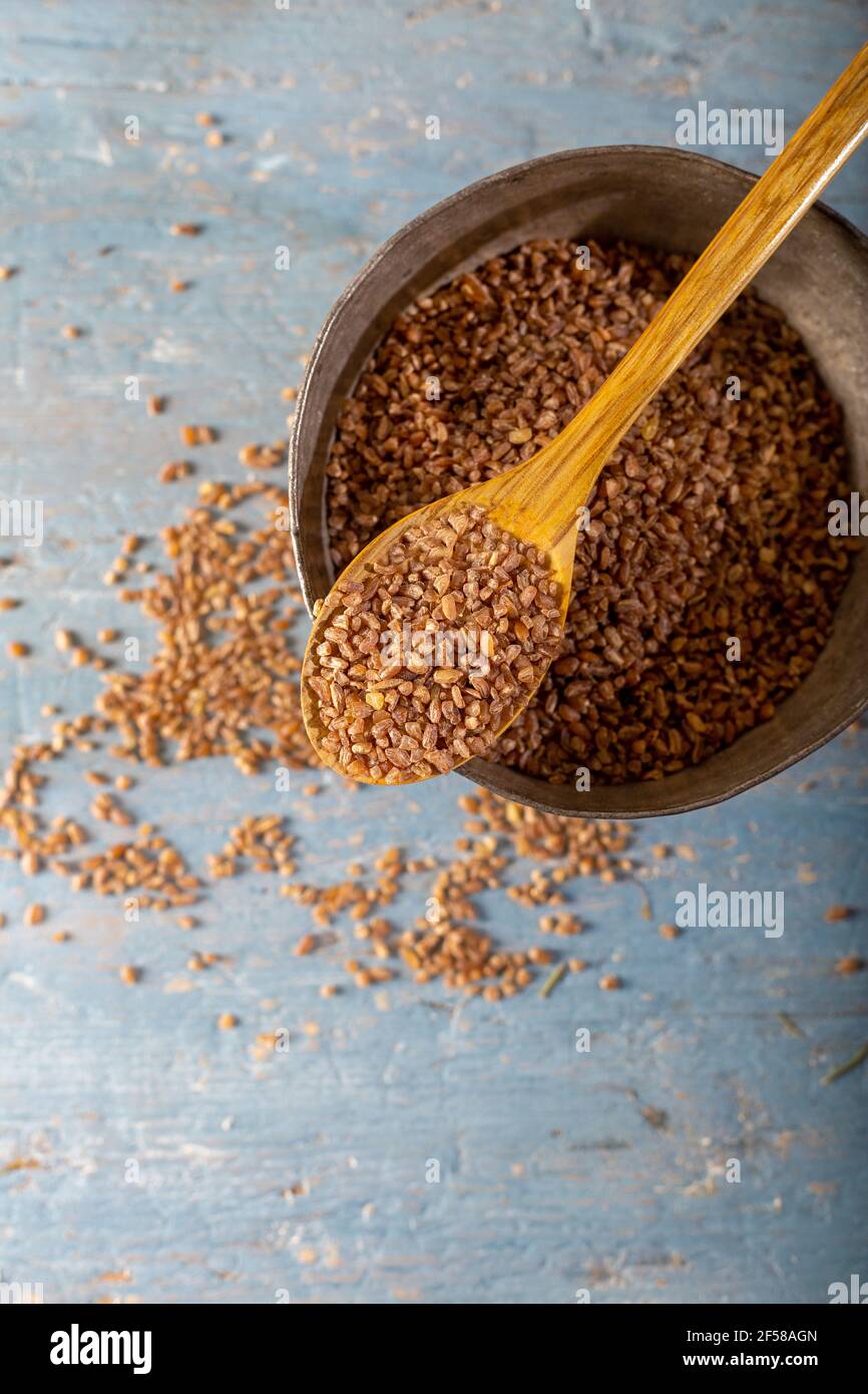 Bulgur d'Einkorn naturel en cuillère en bois sur fond en bois. Vue de dessus. (Siyez). Banque D'Images