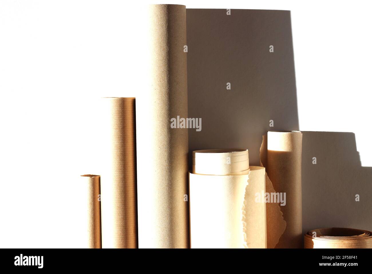 Variété de rouleaux de papier Kraft sur fond blanc. Modèle de conception abstrait. Banque D'Images
