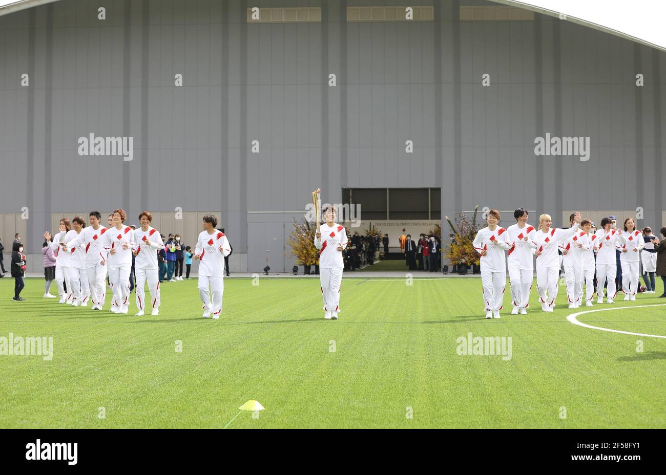 Fukushima, Fukushima du Japon. 25 mars 2021. Iwashimizu Azusa (C) et d'autres anciens membres de 'Nadeshiko Japon', l'équipe nationale de football des femmes du Japon, courent comme torchbearers dans la première partie du relais de la torche pour les Jeux Olympiques de Tokyo au Centre national d'entraînement de J-Village à Futaba, Fukushima du Japon, le 25 mars 2021. Credit: Du Xiaoyi/Xinhua/Alay Live News Banque D'Images