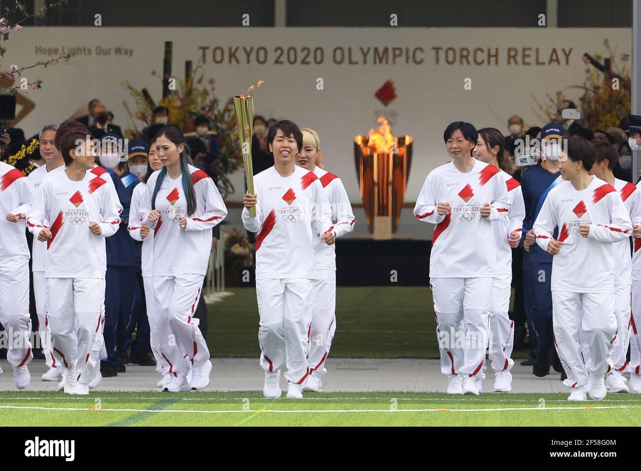 Fukushima, Fukushima du Japon. 25 mars 2021. Iwashimizu Azusa (C) et d'autres anciens membres de 'Nadeshiko Japon', l'équipe nationale de football des femmes du Japon, courent comme torchbearers dans la première partie du relais de la torche pour les Jeux Olympiques de Tokyo au Centre national d'entraînement de J-Village à Futaba, Fukushima du Japon, le 25 mars 2021. Credit: Du Xiaoyi/Xinhua/Alay Live News Banque D'Images