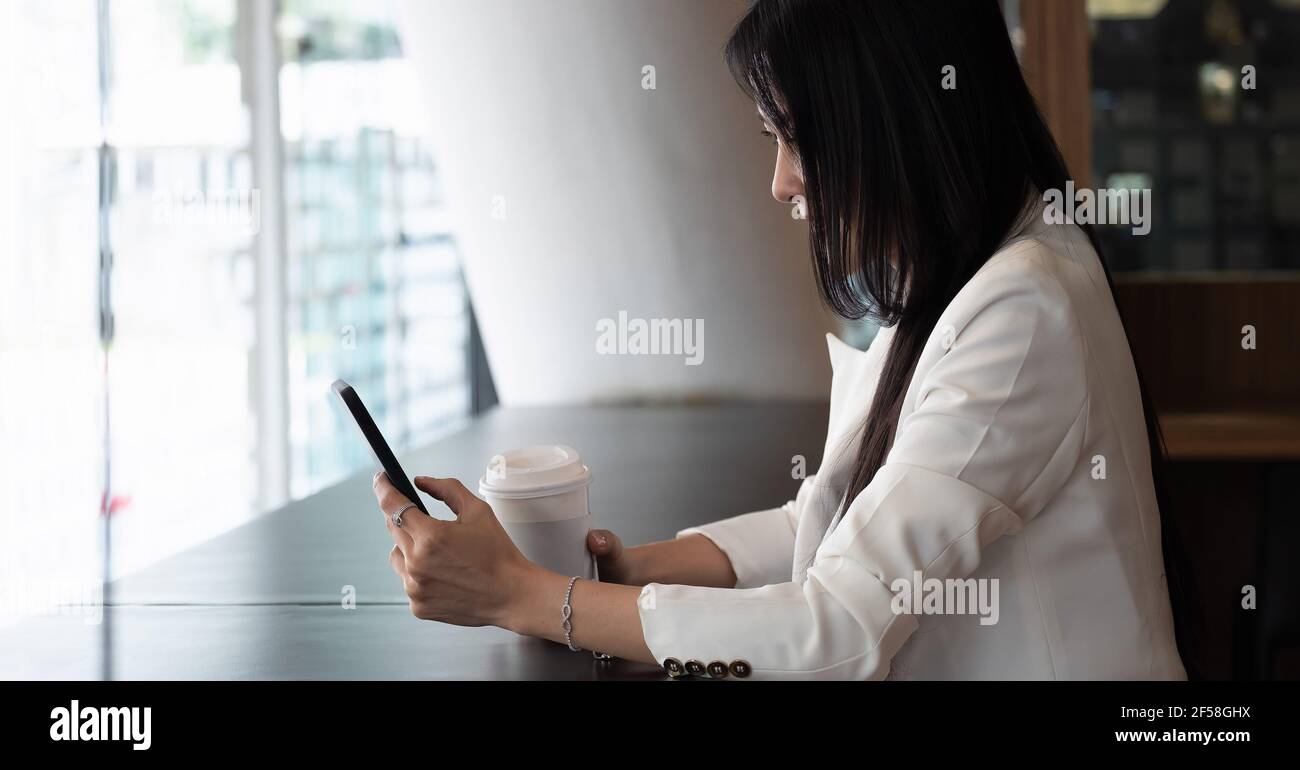 Photo d'une femme d'affaires utilisant un smartphone pour passer des appels vidéo pendant son travail à domicile. Banque D'Images