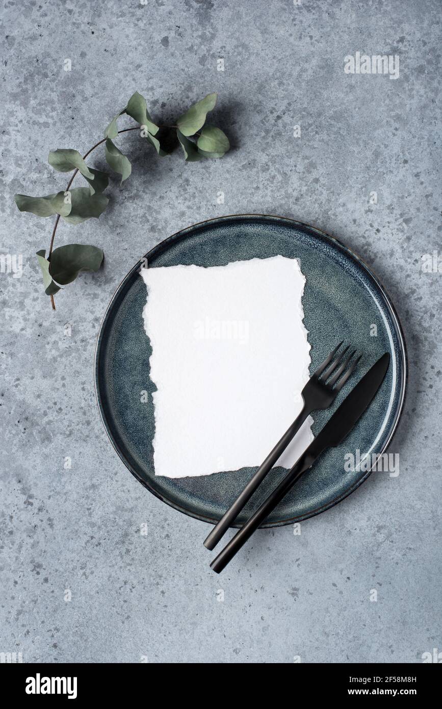 Une assiette vide et des couverts sur une table grise. Banque D'Images