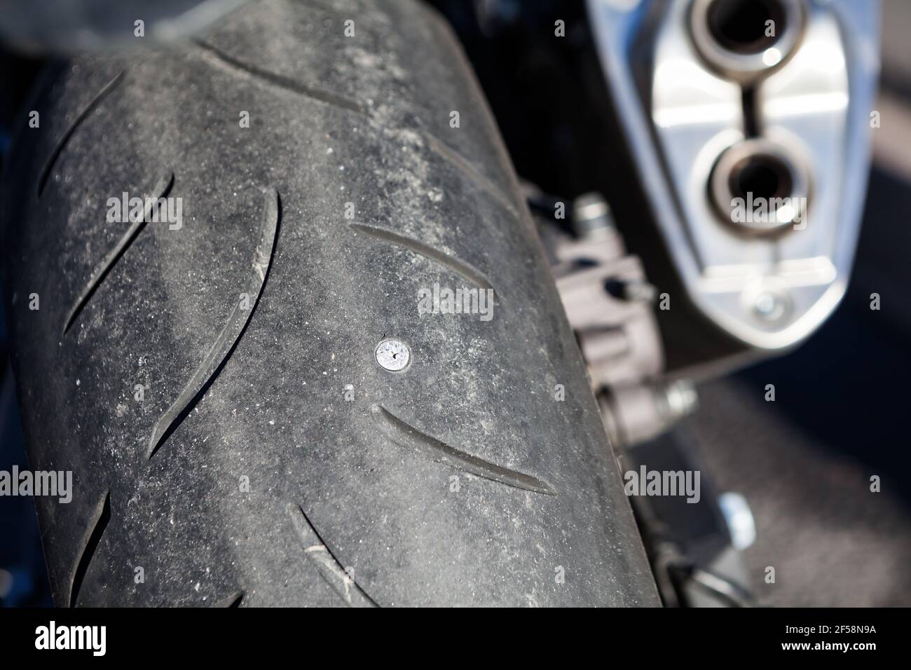Clou à vis perforant le pneu de moto. Vue rapprochée de la roue arrière  Photo Stock - Alamy