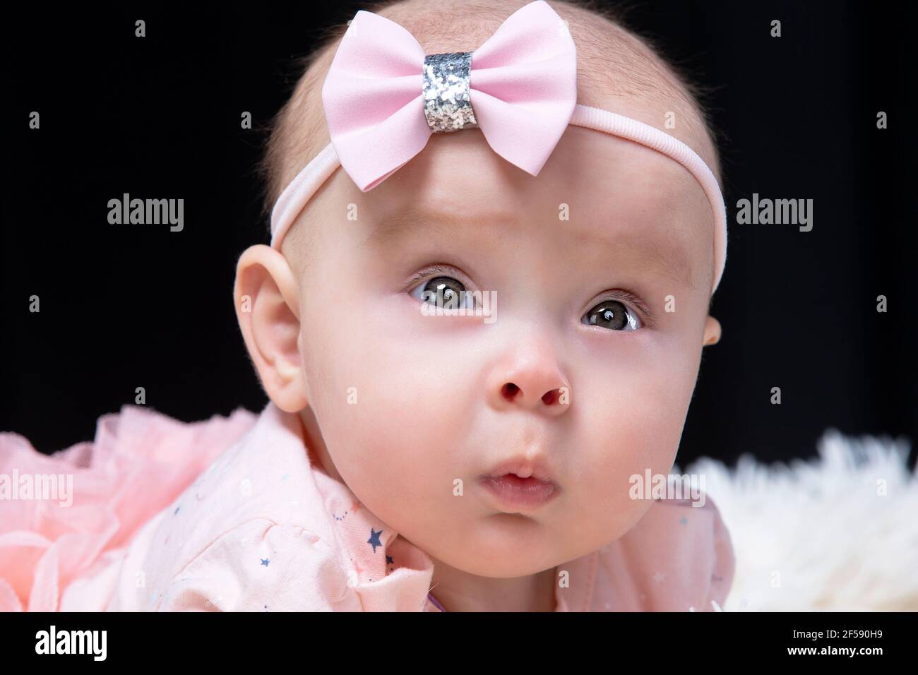 Belle Petite Fille En Vetements Roses Sur Fond Noir Bebe A Quatre Mois Un Enfant Drole Photo Stock Alamy