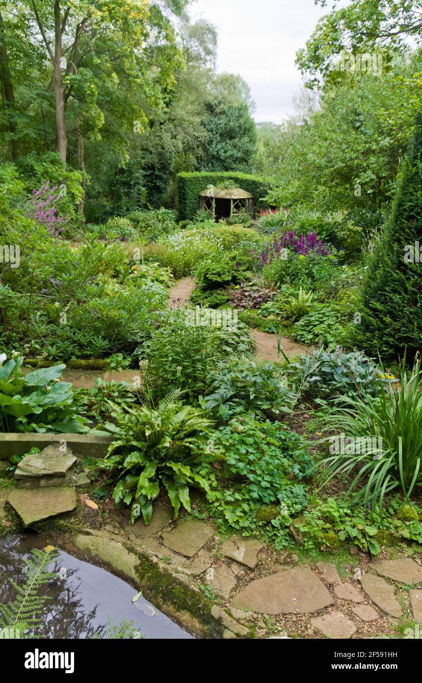 Sentier pavé aux frontières herbacées en été, Coton Manor Gardens, Northamptonshire, Royaume-Uni Banque D'Images