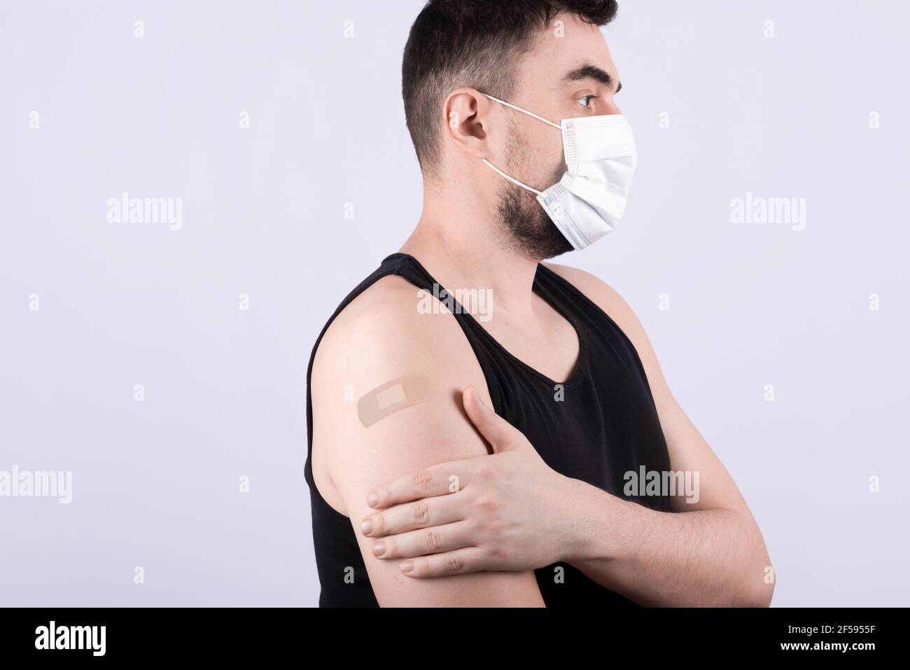 Jeune homme avec bandage adhésif sur son bras après corona vaccination Banque D'Images
