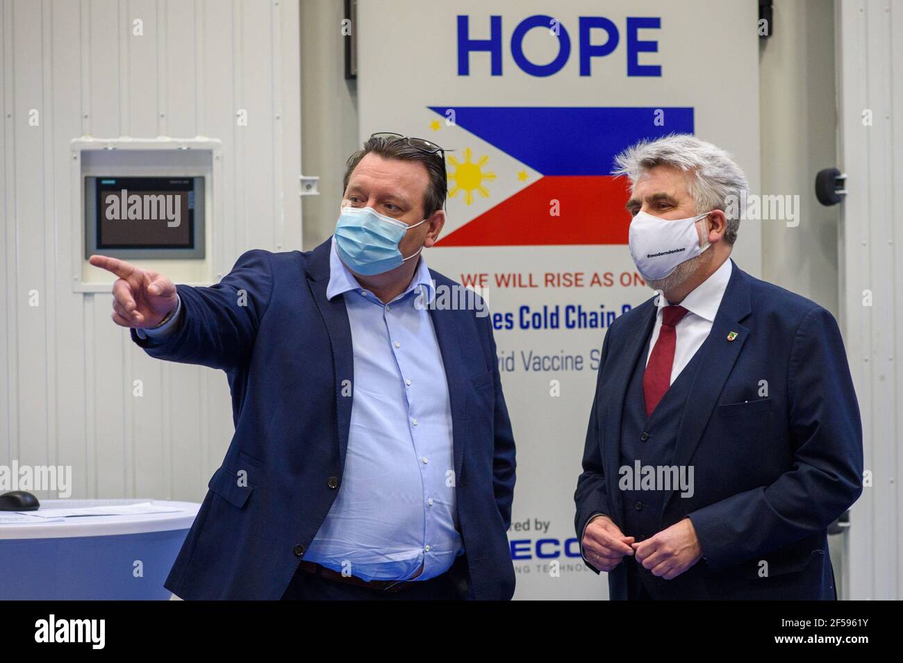 25 mars 2021, Saxe-Anhalt, Bitterfeld-Wolfen: Enrico Klauer (l), directeur général du groupe Mecotec, et Armin Willingmann (SPD), ministre de l'économie, de la science et de la numérisation de l'État de Saxe-Anhalt, se tiennent devant le conteneur mobile hybride MMecotec 'MCF-8', qui arbore le drapeau philippin et l'espoir. Le conteneur peut transporter et stocker environ un demi-million de doses de vaccin à moins 20 à moins 80 degrés Celsius. Pendant 24 heures, le conteneur peut fonctionner sans source d'alimentation externe ni ravitaillement des générateurs diesel intégrés. Le premier conteneur doit être supprimé Banque D'Images