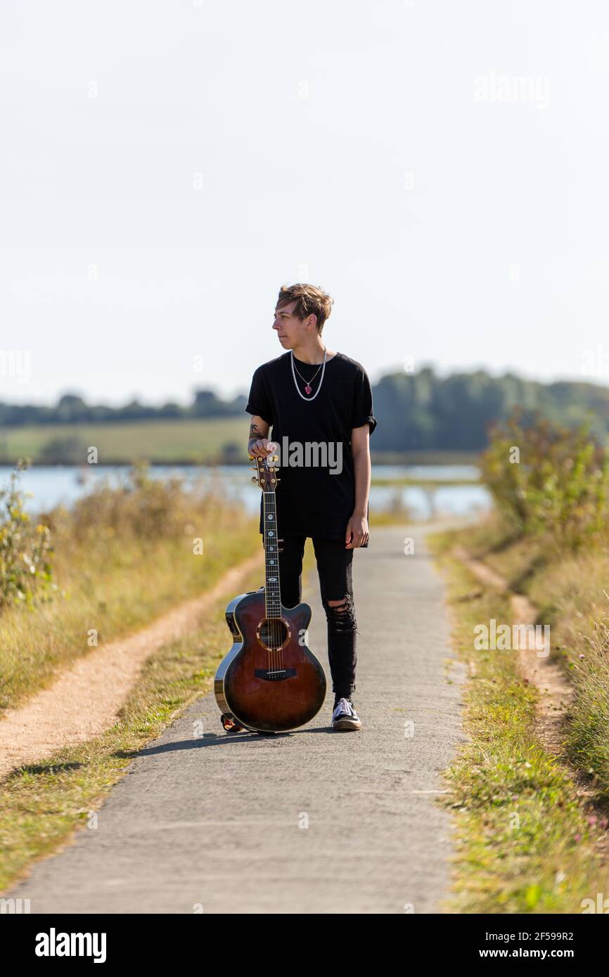 Woodbridge, Suffolk, Royaume-Uni septembre 20 2020: Une femme de 20 quelque chose de relaxant et posant avec sa guitare acoustique Banque D'Images