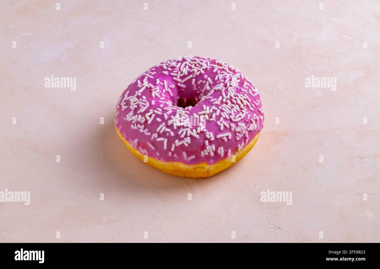 Beignet rose décoré de saupoudres de pâtisserie Banque D'Images