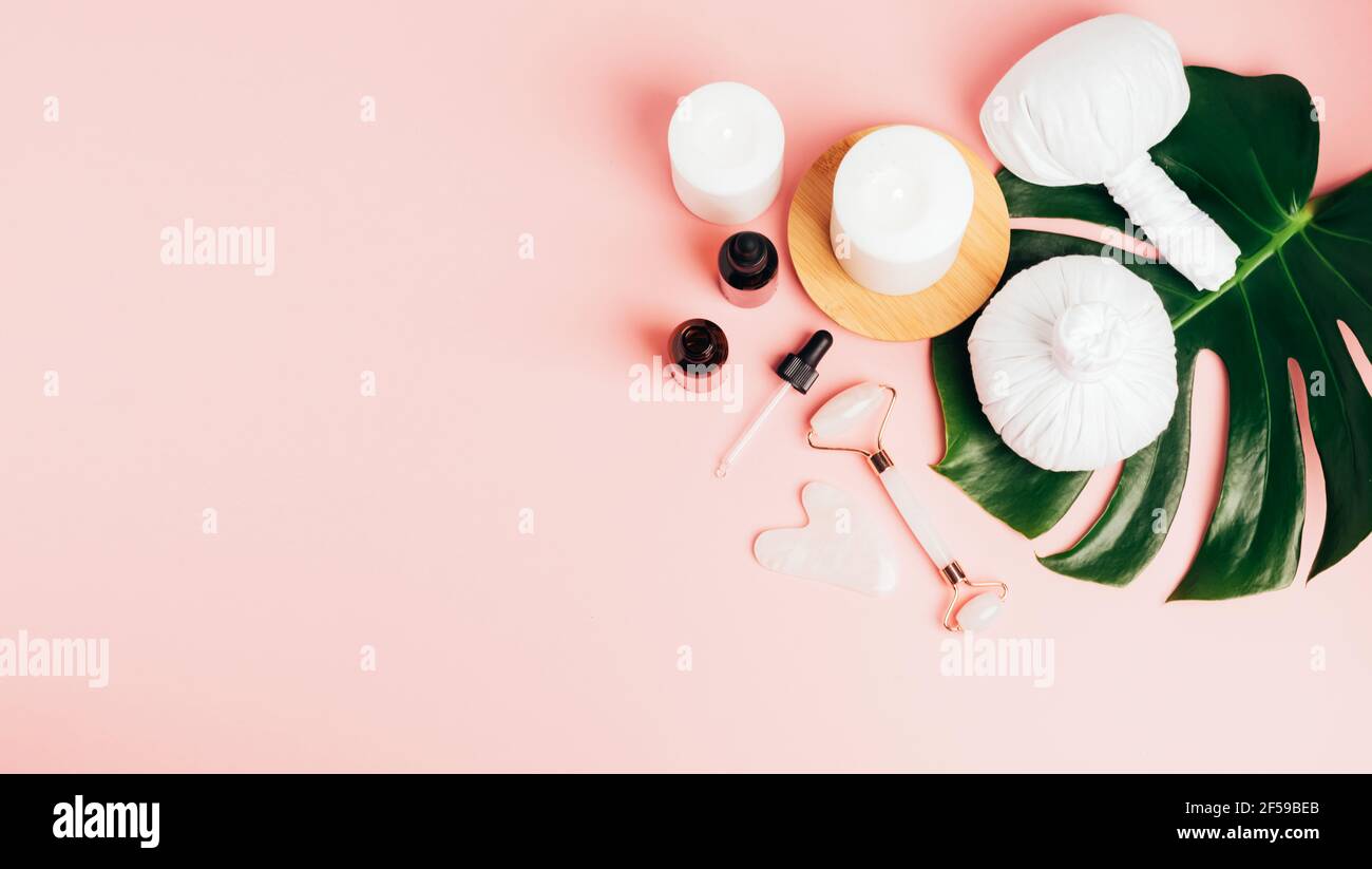Composition spa sur fond rose pastel. Cosmétiques naturels bio bouteille d'huile, crème, argile, sel, outil de massage gua sha accessoires plan Banque D'Images