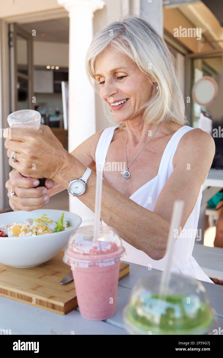 Portrait en gros plan d'une femme âgée en bonne santé qui mange à l'extérieur café Banque D'Images