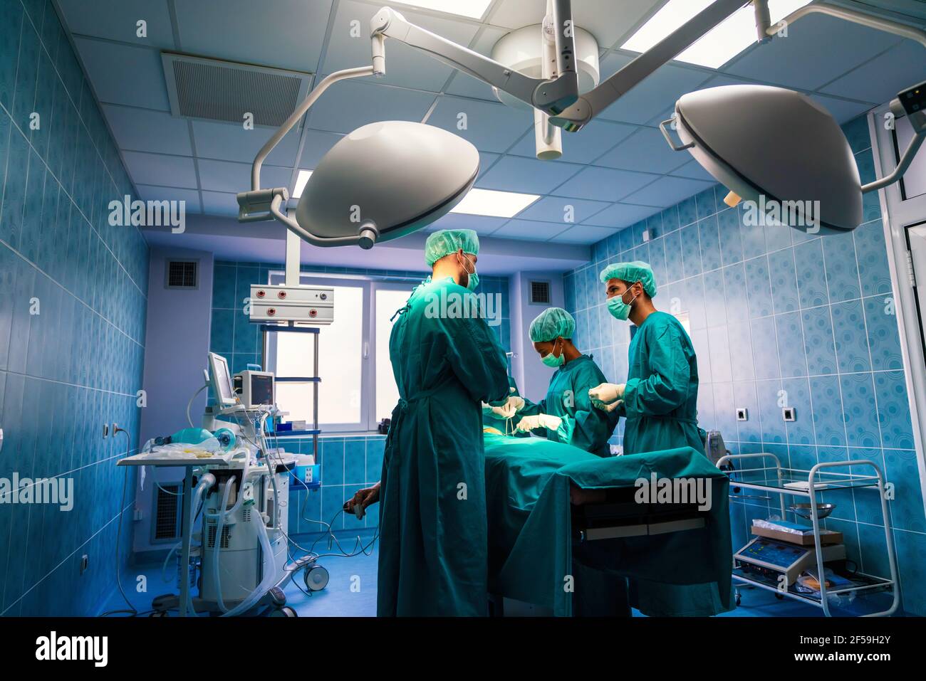 Fonctionnement de l'équipe de chirurgie dans une salle chirurgicale Banque D'Images Fonctionnement de l'équipe de chirurgie dans une salle chirurgicale Banque D'Images