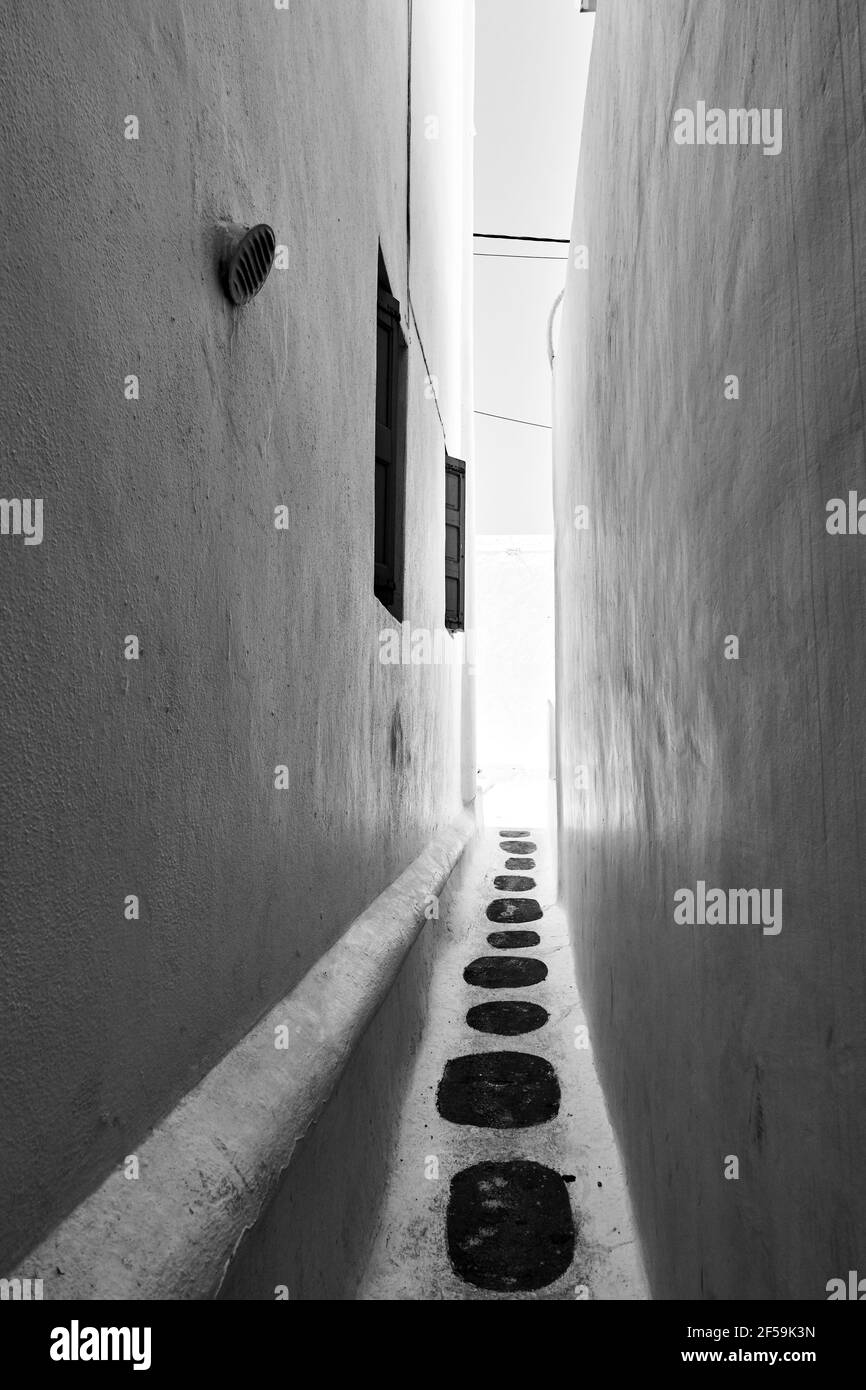 Ruelle très étroite dans la ville de Chora dans l'île de Mykonos, Grèce, architecture grecque, paysage urbain. Photographie en noir et blanc Banque D'Images