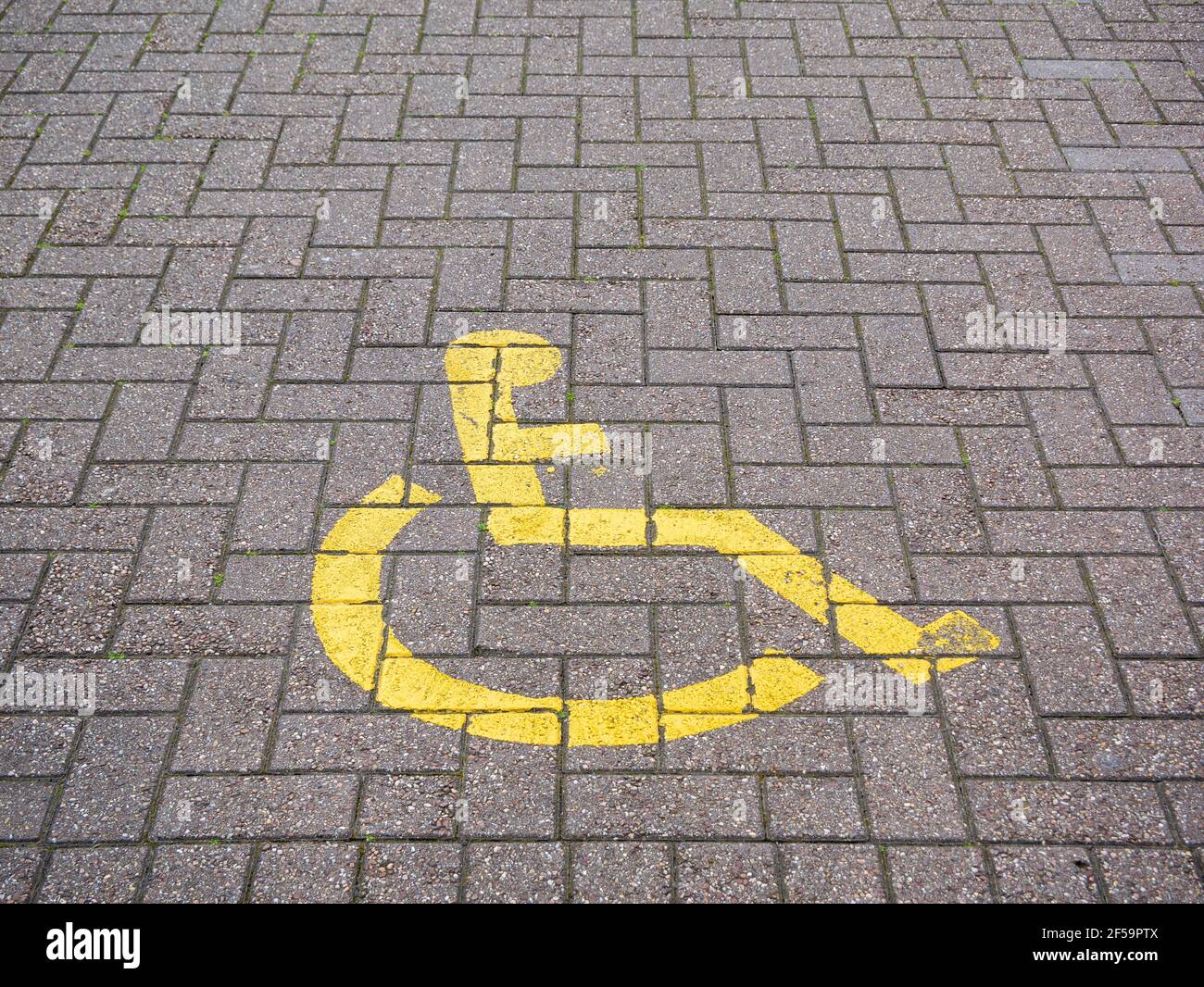 Un panneau de la baie de stationnement pour handicapés peint au sol d'un parking dans un centre commercial au Royaume-Uni. Banque D'Images