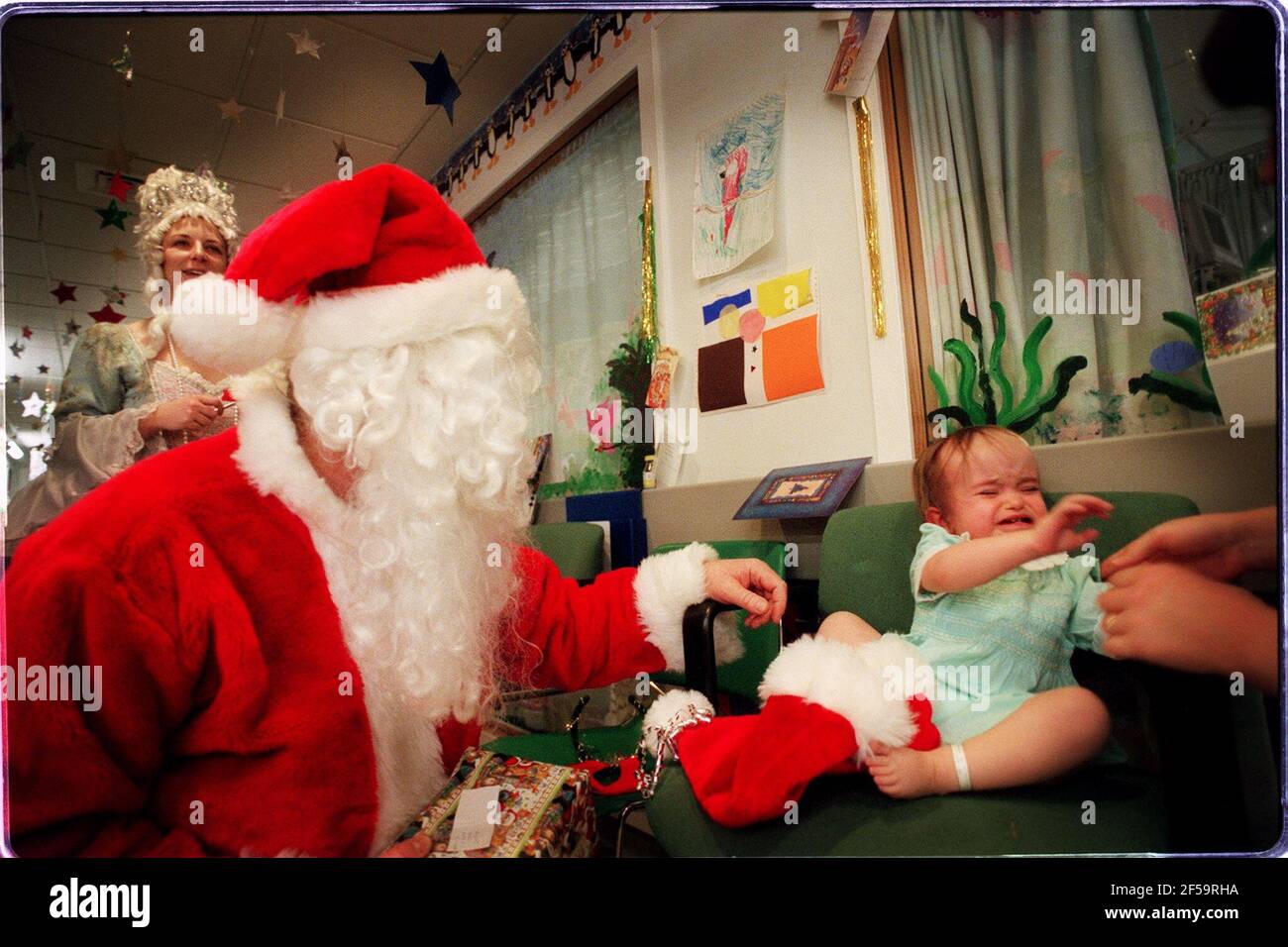 Visite de Noël de père à l'hôpital Great Ormond Street. Photos prises sur Parrot Ward (neurochirurgical). L'hôpital avait deux visites du Père Christmases; celle-ci est Peter Jardine, une infirmière principale du Théâtre cardiaque. Anyes Rodgers, 17 mois, de Sawbridgeworth, qui a de l'hydrocéphalie. Banque D'Images