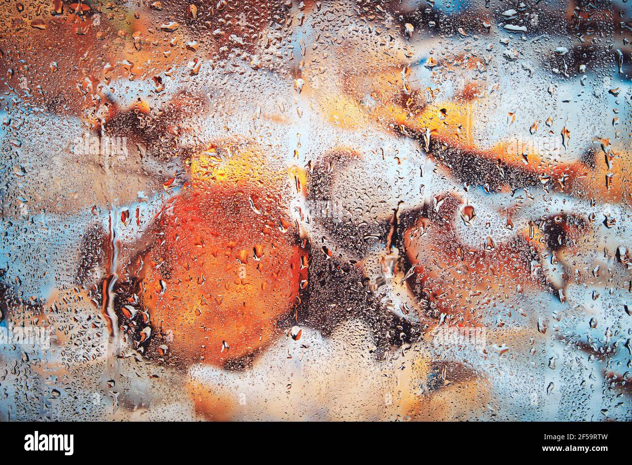 Tombé, feuilles d'automne jaunées derrière le verre humide après la pluie.arrière-plan verre fogé avec le feuillage. Banque D'Images