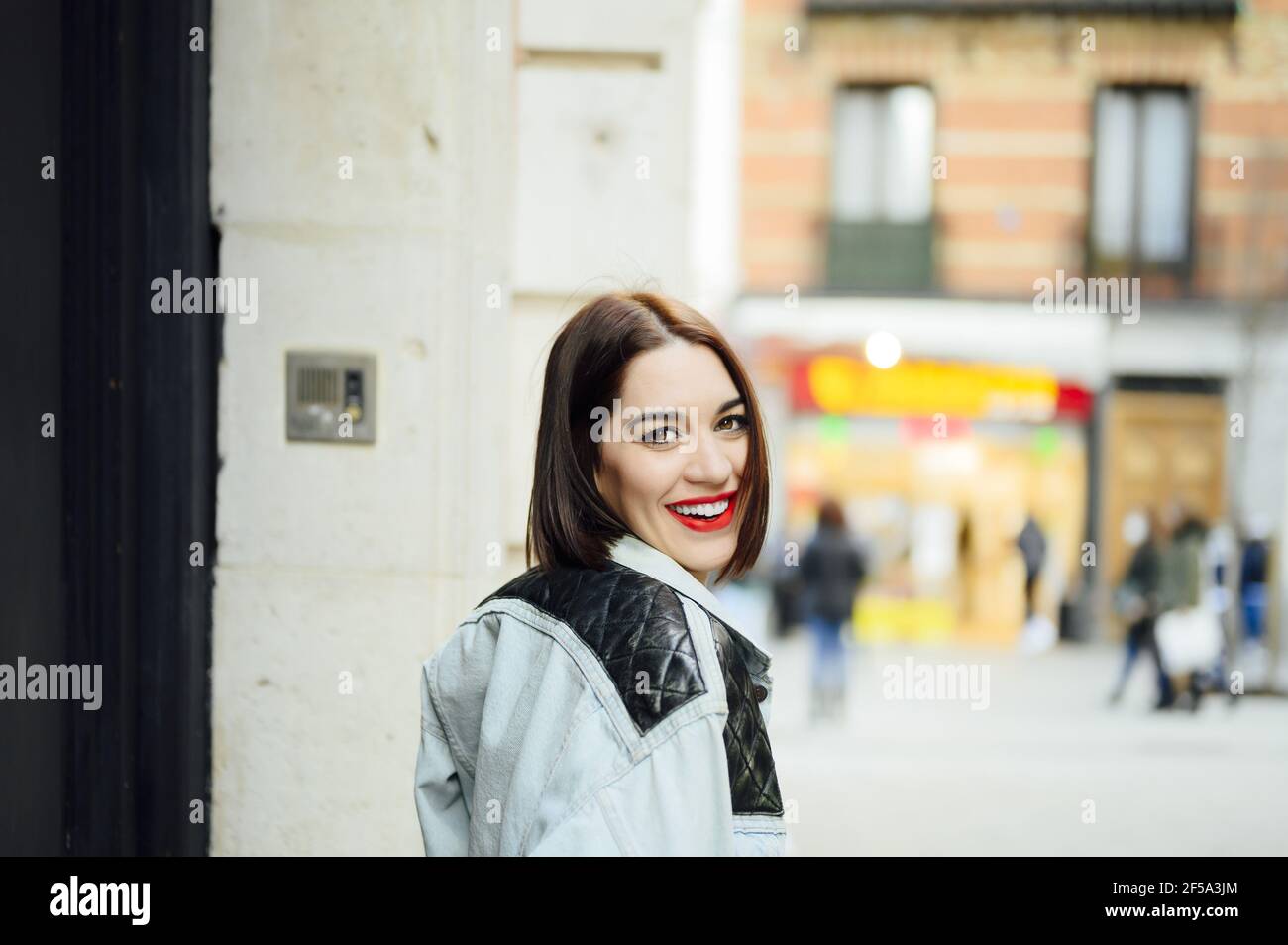 Bonne fille espagnole belle avec un style bob coupe de cheveux et rouge à lèvres posant sur la rue Banque D'Images