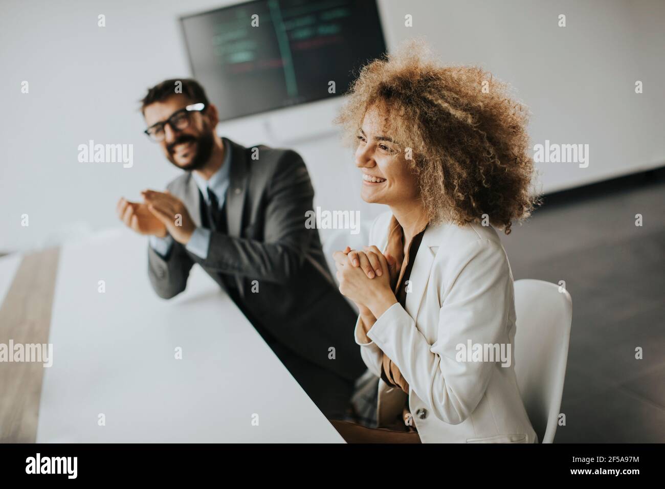 Groupe multiethnique de gens d'affaires travaillant ensemble et applaudissant après réunion réussie au bureau Banque D'Images