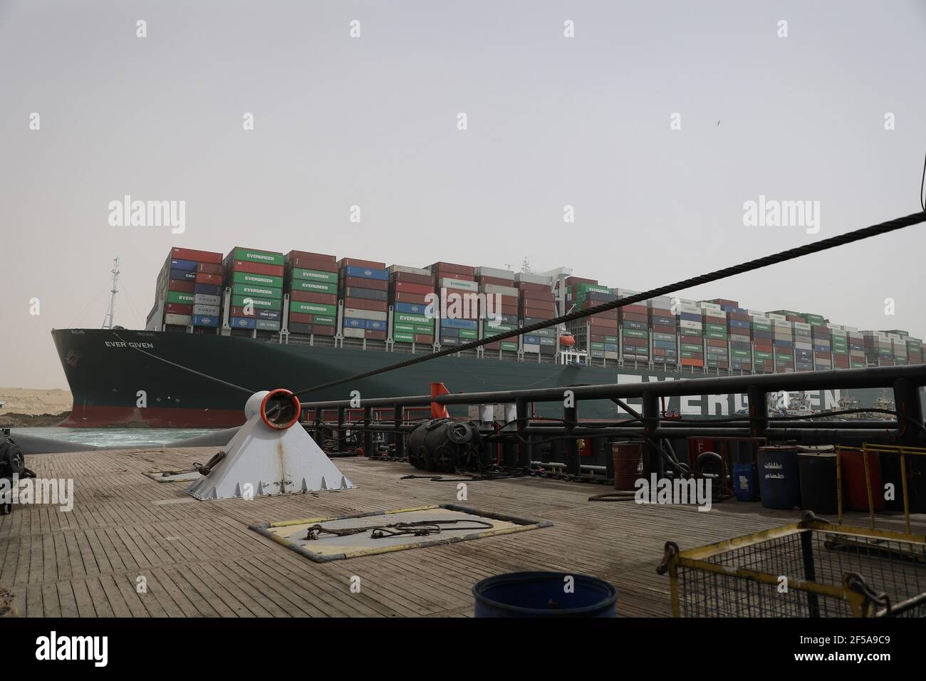 (210325) -- LE CAIRE, le 25 mars 2021 (Xinhua) -- UN navire de sauvetage travaille sur le site d'un navire à conteneurs piégé sur le canal de Suez en Égypte le 25 mars 2021. La navigation dans le canal de Suez a été suspendue temporairement jusqu'à la fin des travaux de re-flottaison sur un navire ancré dans un nouveau cours, a déclaré jeudi Oussama Rabie, président de l'Autorité du canal de Suez (SCA). Le navire à conteneurs portant le drapeau du Panama, d'une capacité de 224,000 tonnes, a été mis à la terre tôt mardi dans le nouveau passage après avoir perdu la capacité de conduire dans des vents violents et une tempête de poussière, a déclaré l'ACR mercredi dans une déclaration. (Auth. Canal de Suez Banque D'Images