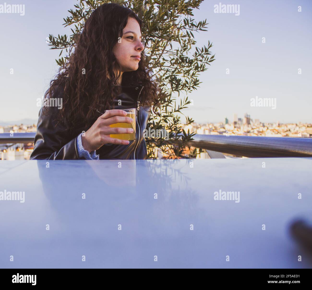 jeune femme ayant une bière sur un toit-terrasse Banque D'Images