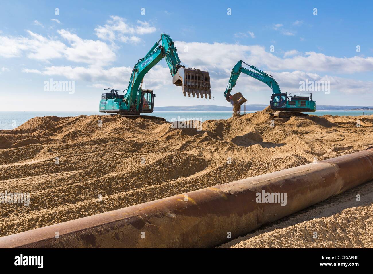 Les excavateurs Ovenden SK500 déplacent du sable sur la plage pour des travaux de réapprovisionnement de plage à Bournemouth et Poole Beaches, Dorset UK en mars Banque D'Images