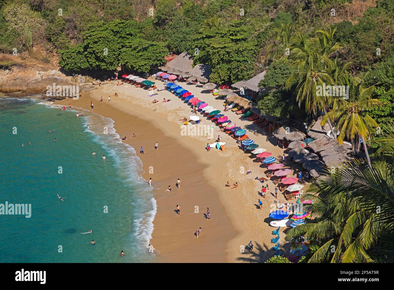 Les touristes se baladent et nagent à Playa Carrizalillo, crique abritée avec plage de sable près de Puerto Escondido, San Pedro Mixtepec, Oaxaca, Mexique Banque D'Images