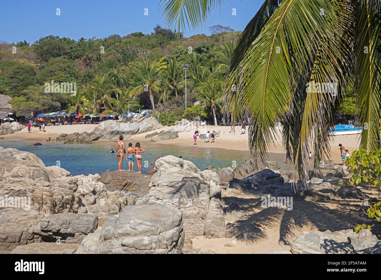 Touristes à la crique abritée avec plage de sable près de Puerto Escondido, San Pedro Mixtepec, Oaxaca, Mexique Banque D'Images