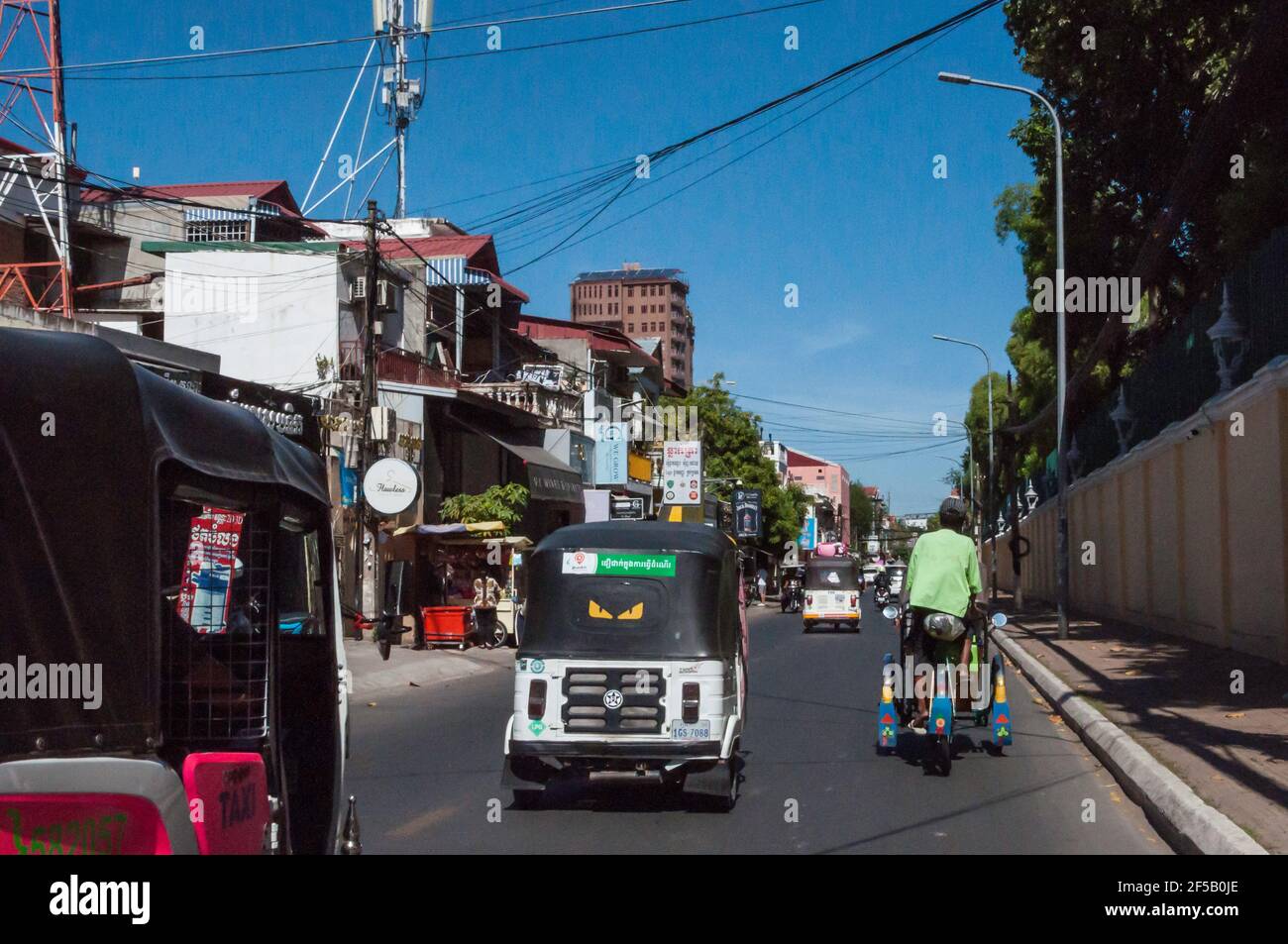 Carte routière de Phnom Penh, avec ses usagers typiques de la route et ses tuk tuk Banque D'Images