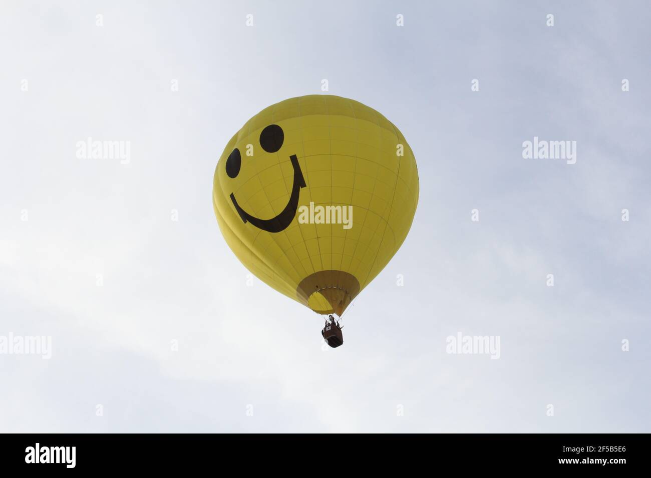 un ballon d'air chaud jaune avec un sourire riant est voler dans l'air Banque D'Images