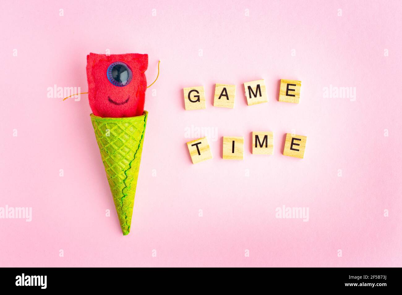 Monstre gai à un œil dans un cône de glace, inscription temps de jeu. Banque D'Images