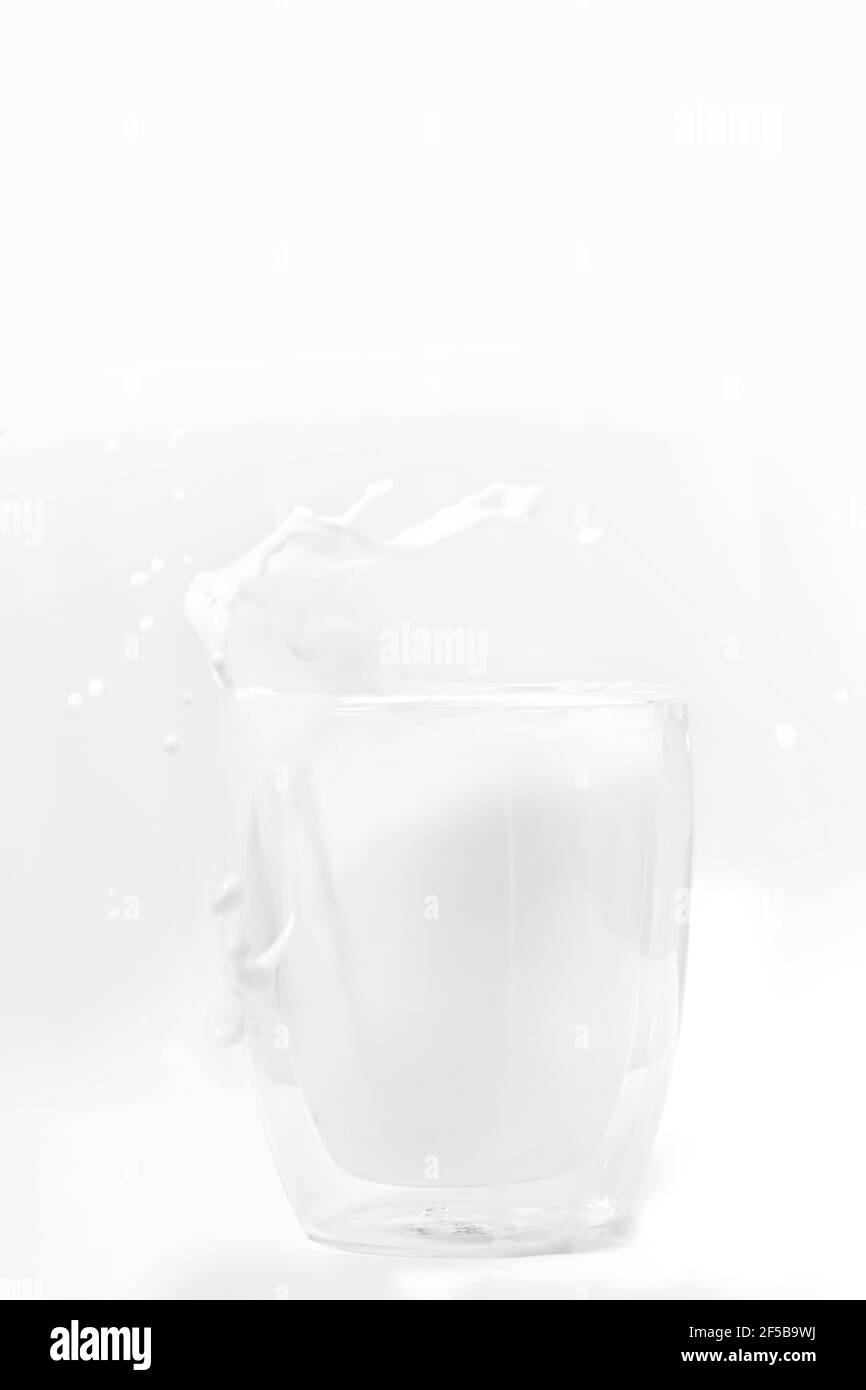 Parfait verre à lait blanc éclaboussant sur fond blanc Banque D'Images