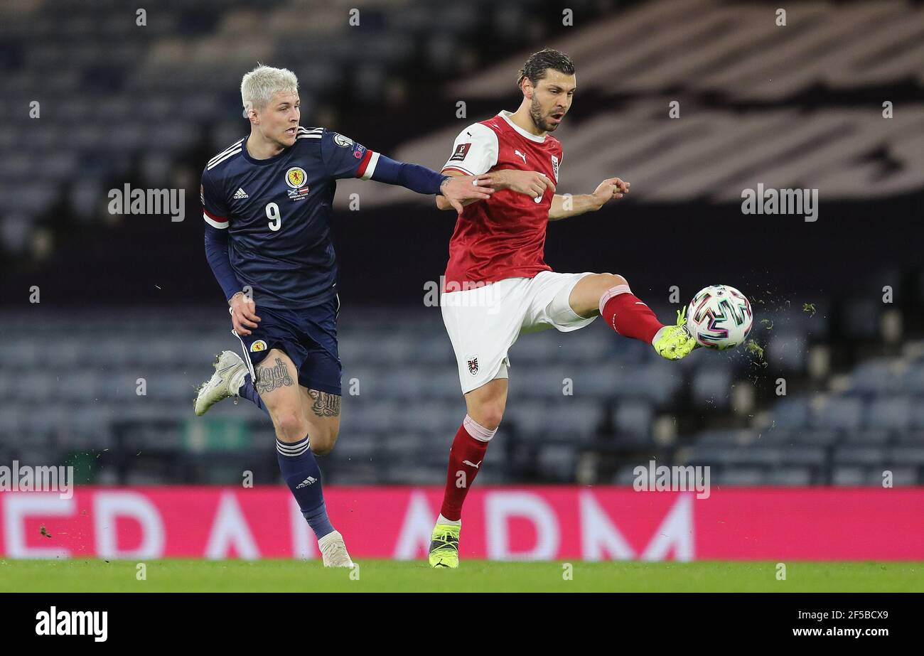 Lyndon dykes (à gauche) en Écosse et Aleksander Dragovic en Autriche se battent pour le ballon lors du match de qualification de la coupe du monde FIFA 2022 à Hampden Park, Glasgow. Date de la photo: Jeudi 25 mars 2021. Banque D'Images