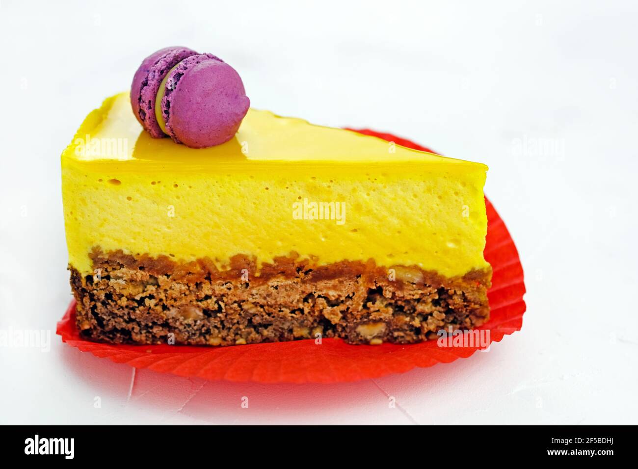 Tranche de gâteau jaune avec pâtes. Cheesecake à la mangue sur une pâte à croûte courte. Délicieux dessert lumineux sur une assiette blanche. Soufflé au citron Banque D'Images