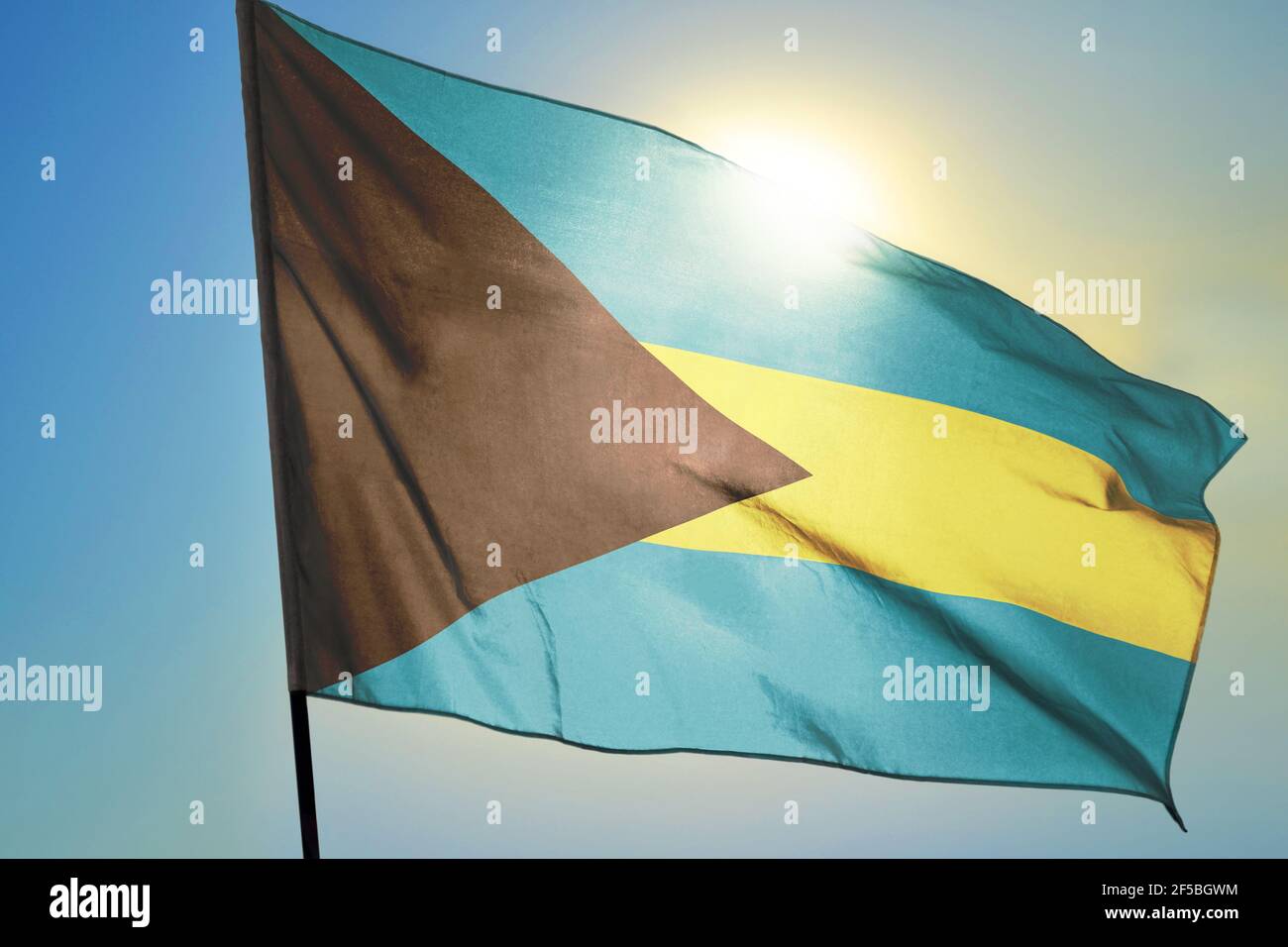 Drapeau des Bahamas agitant sur le vent devant le soleil Banque D'Images