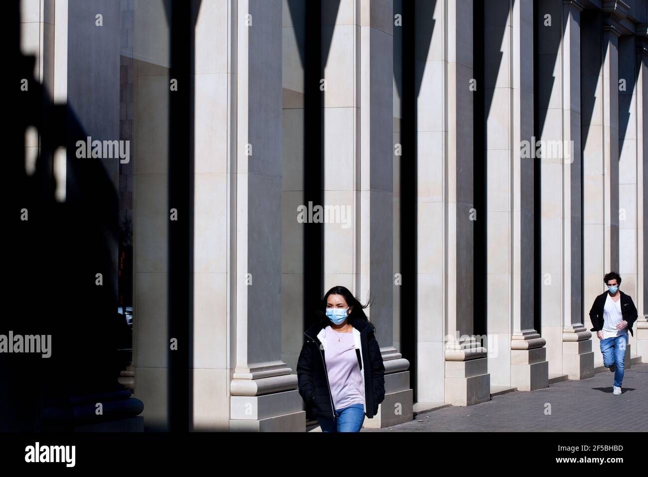 Une jeune femme est poursuivie par un homme dans la rue. Banque D'Images