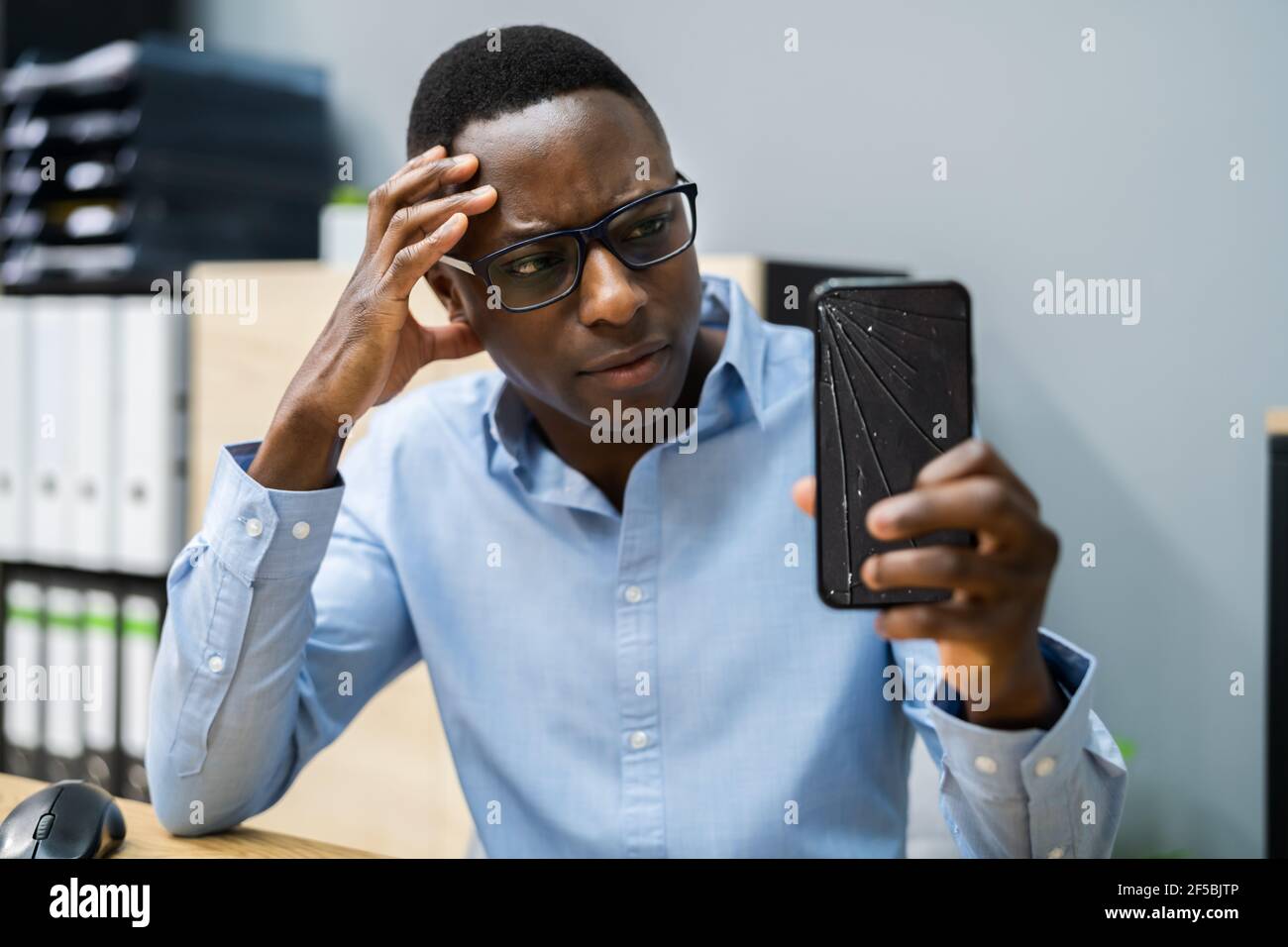 Téléphone cassé fissuré. Réparation de smartphone. Expression inquiète Banque D'Images