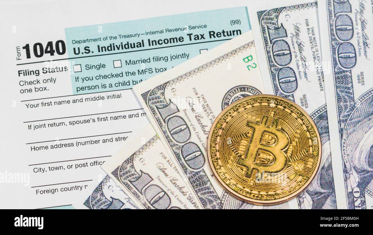Bitcoin le jour de l'impôt. 1040 formulaire prêt à être rempli et retourné. Banque D'Images