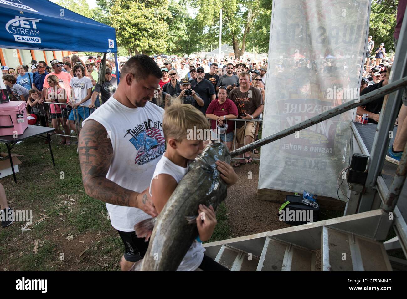 Un nouiller triomphant expose fièrement son poisson-chat à une foule enthousiaste lors du tournoi annuel Okie Noodling à Paul's Valley, Oklahoma. Banque D'Images