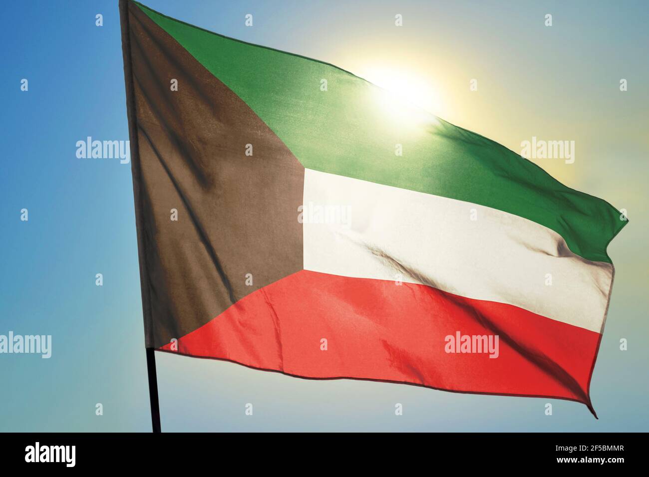 Drapeau koweïtien agitant sur le vent devant le soleil Banque D'Images