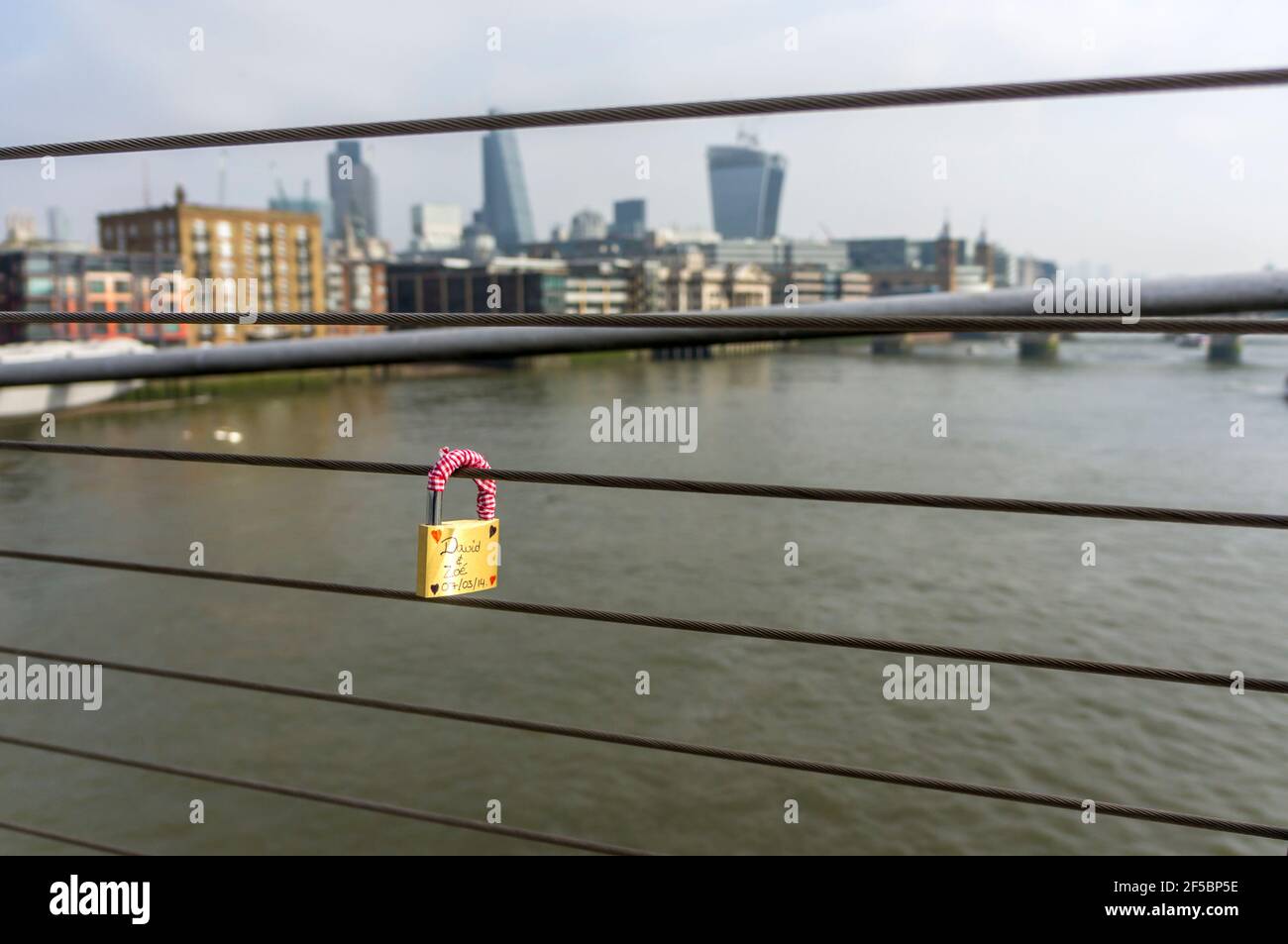 Une seule écluse d'amour sur le pont du millénaire surplombant la ville de Londres en face de la Tamise. Banque D'Images