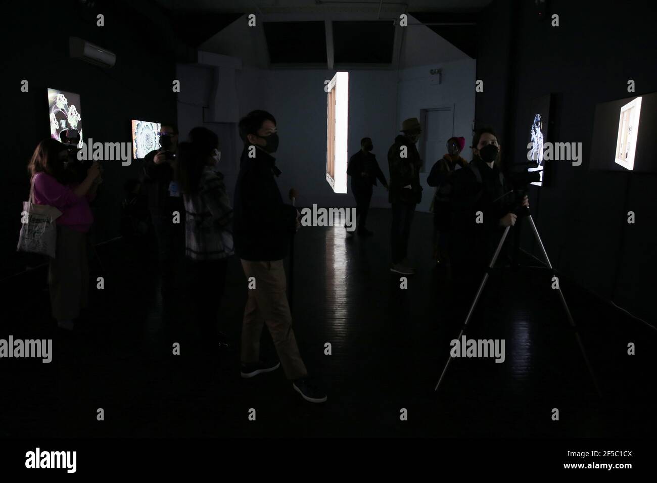 New York, États-Unis. 25 mars 2021. Les gens passent par les œuvres d'art de la NFT et les regardent lors d'un aperçu de presse et de l'ouverture officielle de la galerie SuperChief NFT, la galerie physique du monde consacrée exclusivement aux œuvres d'art de la NFT (jetons non fongibles) à New York le jeudi 25 mars 2021. La galerie s'ouvre avec l'exposition « Season One Starter Pack », qui présente une rotation quotidienne des installations artistiques affichées sur des écrans 4K haute résolution. Photo de John Angelillo/UPI crédit: UPI/Alay Live News Banque D'Images