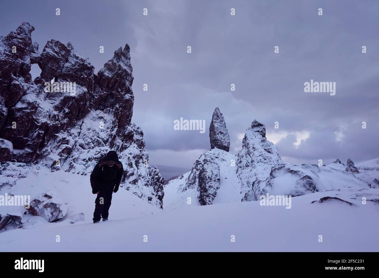 Old Man Storr, Isle Skye, Écosse. Hiver, montagne très enneigée avant le coucher du soleil. mountaineer atteignant le sommet de la montagne Banque D'Images